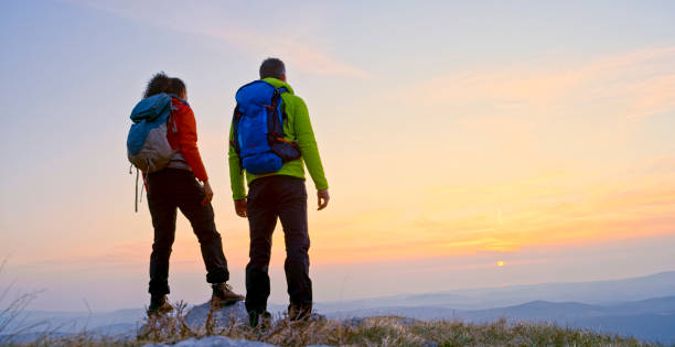 rear view of mature couple standing on mountain - achievement mature adult adult mountain range imagens e fotografias de stock