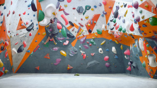 istock Rear view of man climbing indoor artificial wall 1308391645