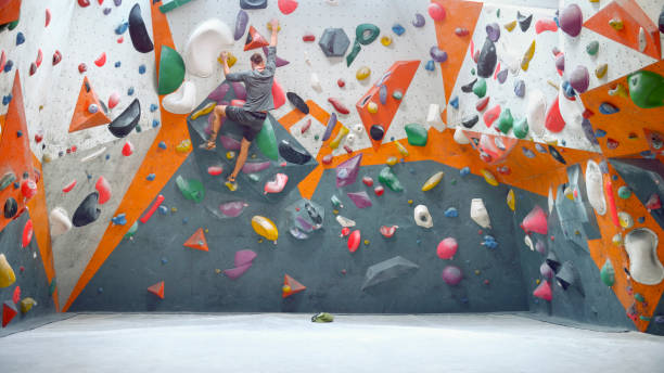 istock Rear view of man climbing indoor artificial wall 1308391802