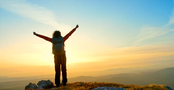 istock Mature woman standing on mountain 1308391999