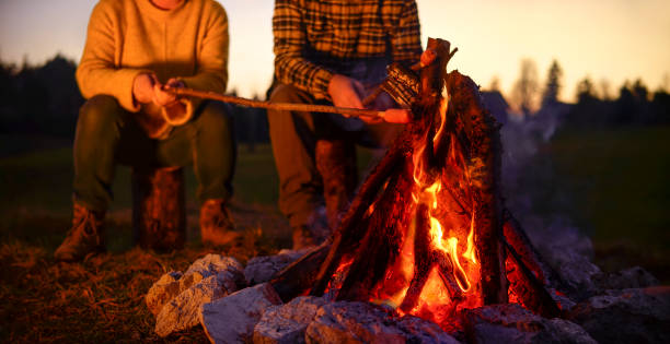 istock Mature couple roasting sausage over camp fire 1308392656