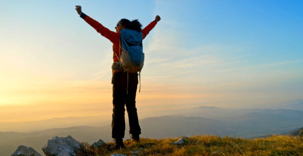 istock Mature woman standing on mountain 1308392692