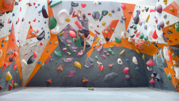 istock Rear view of man climbing indoor artificial wall 1308392712