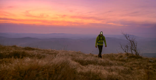 istock Mature man wearing head torch walking on mountain trail 1308392721