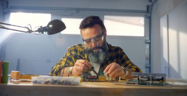 istock Mature man using soldering iron on mother board 1308392791