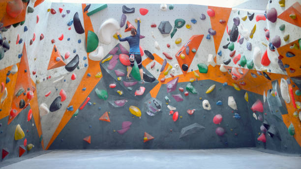 istock Rear view of woman climbing indoor artificial wall 1308393280