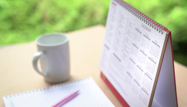 istock Calendar on table with cup of coffee and notebbok, Selective focus. 1308393479