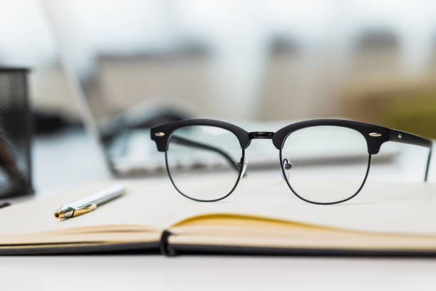istock Close up glasses put on the desk with laptop and note. 1308394260