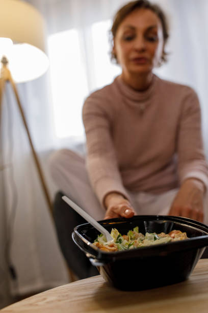 istock Woman reaching for a bowl with her takeaway lunch 1308394292