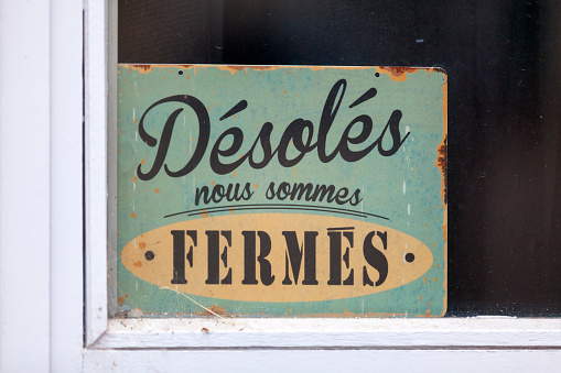Close-up on a closed sign saying in French \