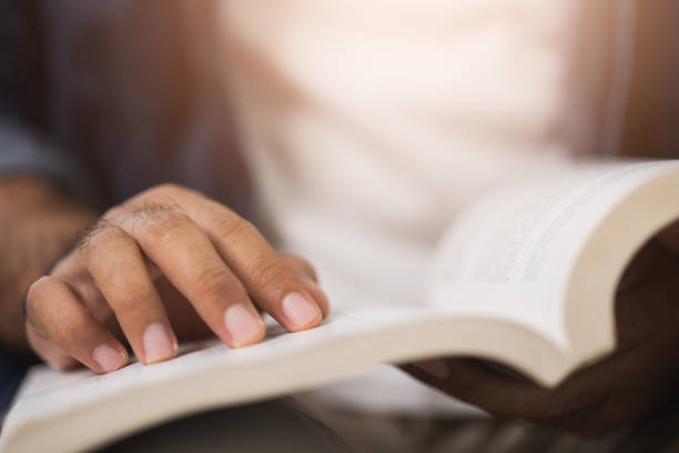 istock Close up male hand open book and reading. 1308394419