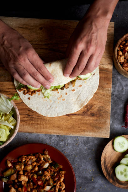 istock young man rolls a durum or a burrito 1308394986