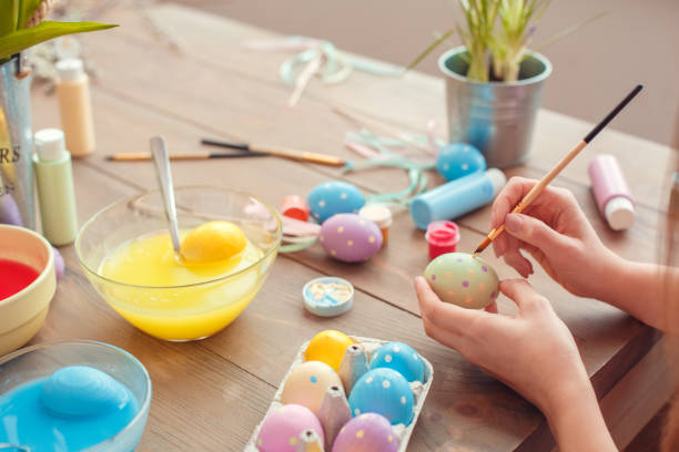 istock Young woman at home easter celbration concept back view sitting coloring eggs painting dots 1308395154