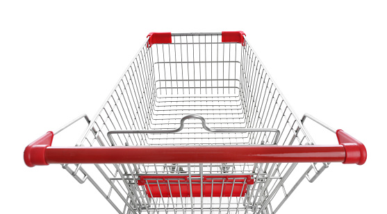 Abandoned shopping cart with groceries in the middle of the aisle in the supermarket. No one is on the photo.