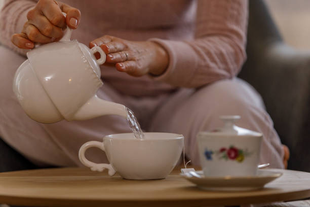 istock Woman pouring herself a cup of tea 1308395930