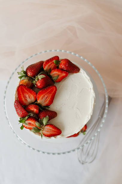 istock white cake with cream garnished with strawberries on a tray 1308397183