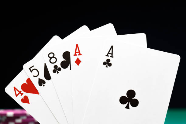 istock Poker chips and playing cards on black background 1308397271