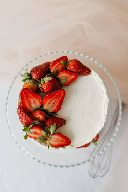 istock white cake with cream decorated with strawberries on a tray top view 1308397345