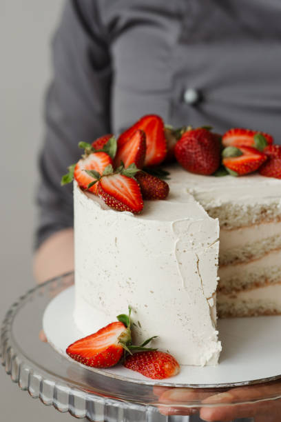 istock waiter holding a tray with a white cake decorated with strawberries 1308397383