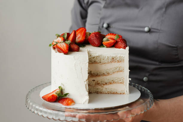 istock waiter holding a tray with a white cake decorated with strawberries 1308397433