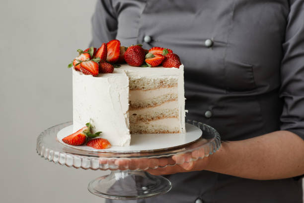 istock waiter holding a tray with a white cake decorated with strawberries without a piece 1308397466
