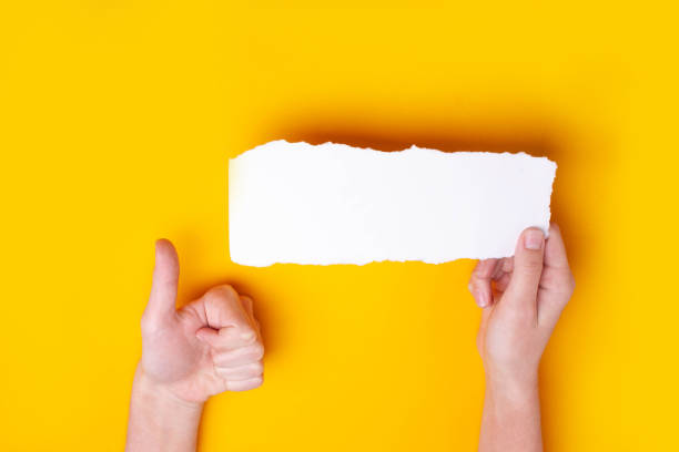 istock The hand holds a blank sheet and shows a thumbs up. Class approval symbol. Empty space 1308397999