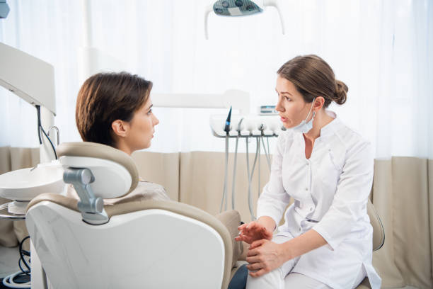 istock A young woman explaining her dental problem to her doctor, the d 1308399126