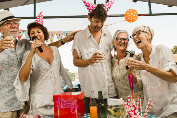 istock Senior people celebrating birthday singing karaoke. 1308399663