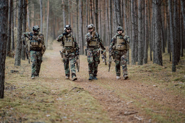 istock Fully equipped soldiers in camouflage uniform returning from reconnaissance in a pine forest 1308399875
