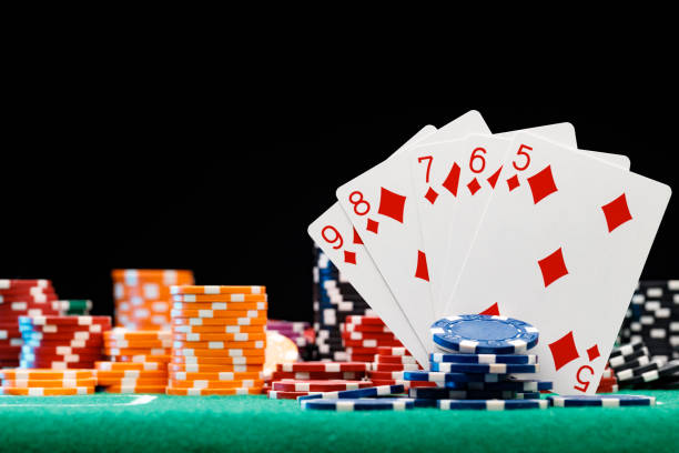 istock Poker chips and playing cards on black background 1308399888