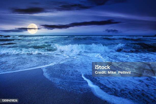 Sea Tide On A Cloudy Night Stock Photo - Download Image Now - Tide, Moon, Beach
