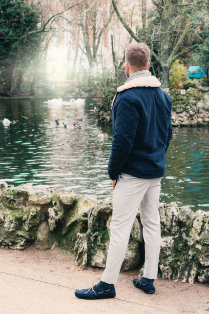 istock back view of a handsome young blond by a lake 1308402624