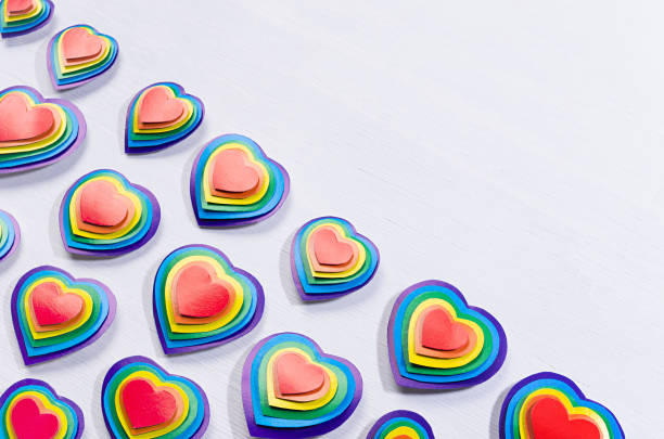 istock Bright rainbow hearts on white wood board, pattern, border, top view. 1308402719