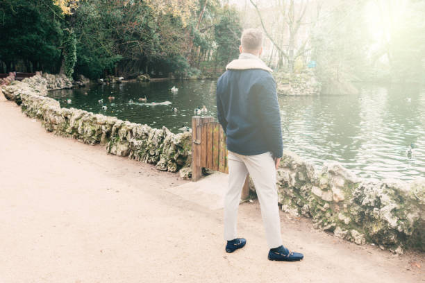 istock back view of a handsome young blond by a lake 1308402725