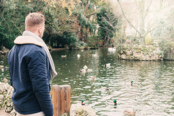 istock back view of a handsome young blond by a lake 1308402755