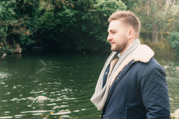 istock attractive young blond bearded man by a lake 1308402801