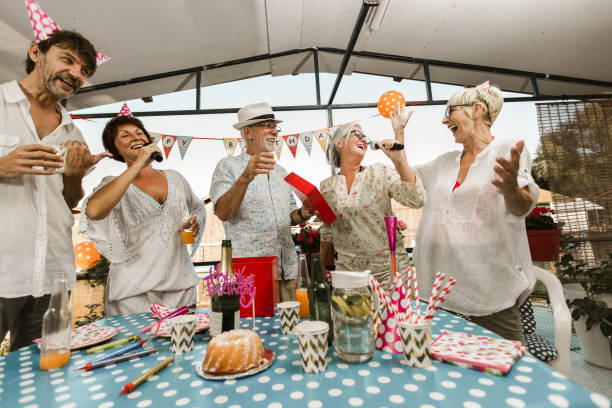 istock Senior people celebrating birthday singing karaoke. 1308403721