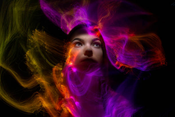 Multicolor abstract portrait of young woman on subject of creativity, imagination and art. lightpainting Fashion model woman in neon light, portrait of beautiful model with fluorescent make-up, Art design of female disco dancers posing in UV, colorful make up. Isolated on black background lightpainting stock pictures, royalty-free photos & images