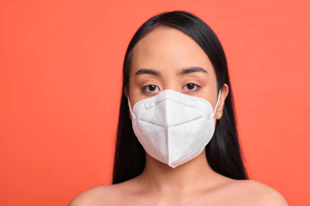 istock One woman wearing a protective face mask. 1308405388