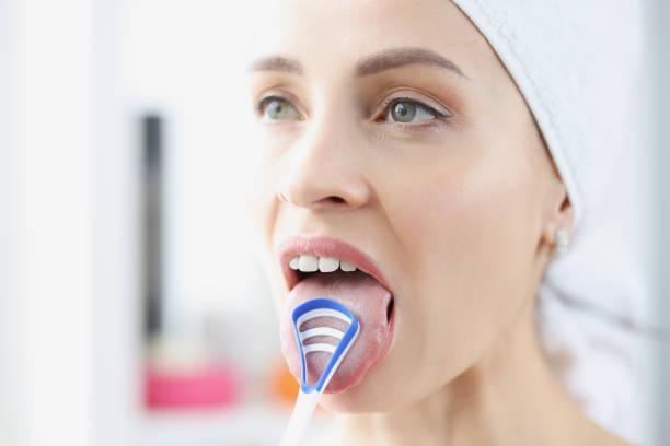 kobieta czyści swój język za pomocą specjalnego skrobaka - healthy lifestyle toothbrush caucasian one person zdjęcia i obrazy z banku zdjęć