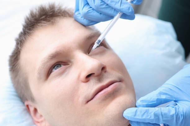 istock Young man is given rejuvenating injection in face 1308406320