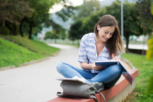 istock Happy female student learning in the park 1308406617
