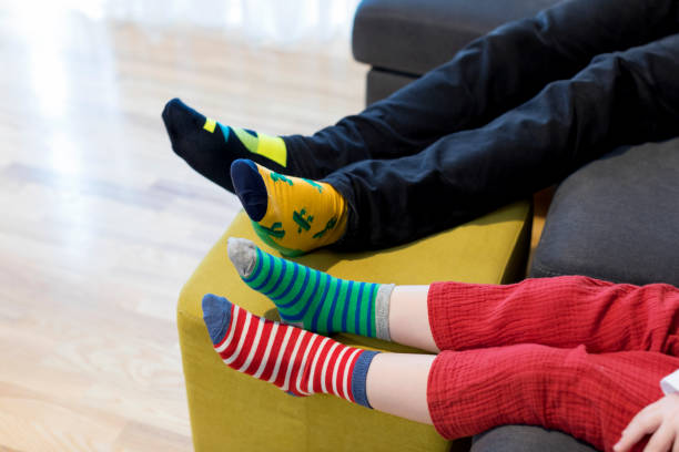 istock Down syndrome awareness concept. Man with boy wearing different socks. 1308410412