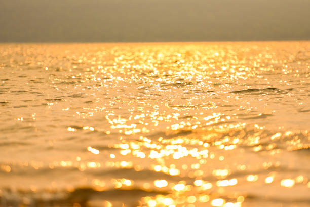 Abstract sunlight reflective on water background, Lights bokeh on water surface at sunset nature summer or spring ocean sea