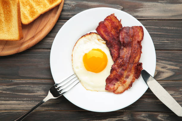 istock Eggs and bacon for breakfast on brown background. English breakfast 1308412449