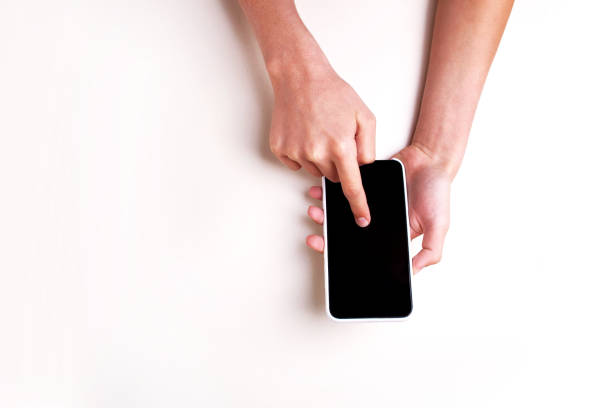 istock Hands hold a phone on a white background isolated. View from above 1308413243