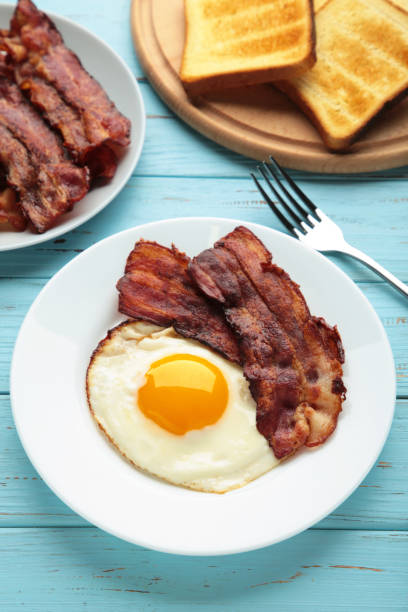 istock Eggs and bacon for breakfast on blue background. English breakfast. 1308413308