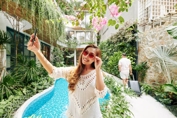 Woman taking selfie by pool