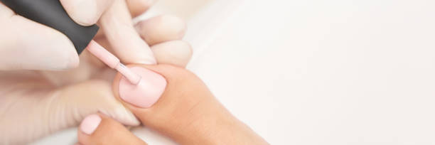 istock Classic pink wedding toe nail manicure on white backdrop. Spa treatment concept 1308413854