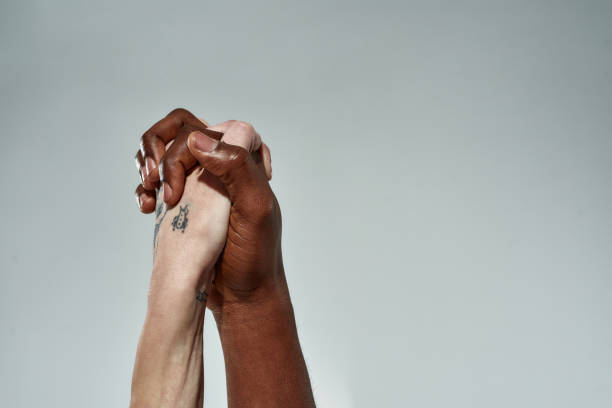 istock Raised hands of multiracial couple clenched into lock 1308416084
